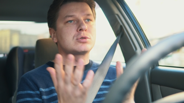A Young Attractive Man Is Driving a Car and Swearing alt