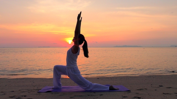 Asian Woman Practicing Yoga at the Sunset Sea