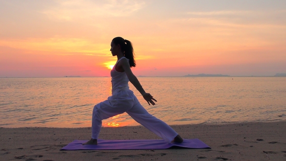 Asian Woman Practicing Yoga at the Sunset Sea