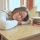 Tired Student Girl with Glasses Sleeping on the Books in the Class