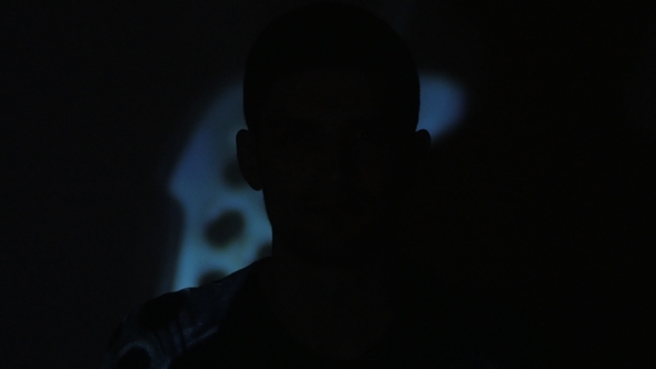 of a Young Man Watching a Video or Film on TV or a Computer Monitor Reflection on His Face alt