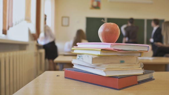 School Break in the Classroom. Books with Apple Are on the Table. School Theme. alt