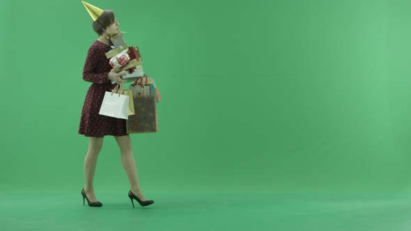 A Young Woman Is Going From Left Side with a Lot of Gifts on the Green Screen