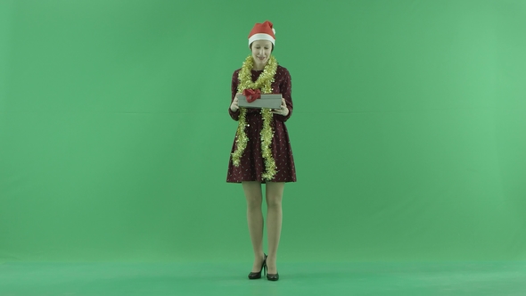 A Young Woman Is Opening the Christmasgift on the Green Screen