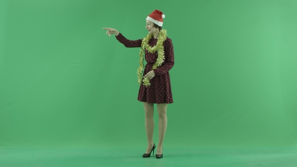 A Young Christmas Woman Calls To Someone From the Left Side on the Green Screen