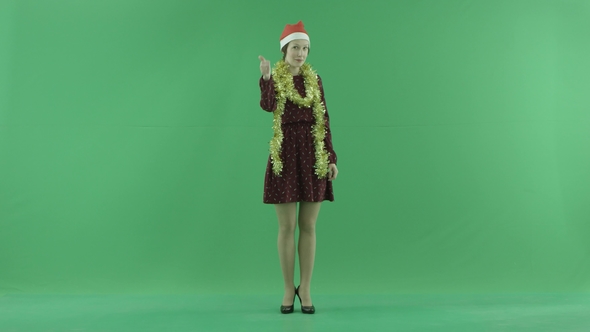 A Young Christmas Woman Is Showing That Something Is Cool on the Green Screen