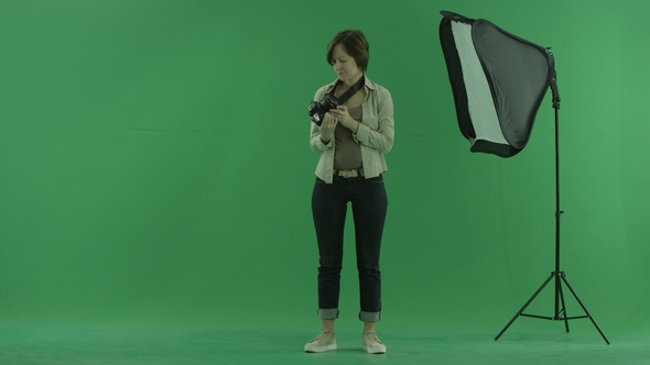 A Young Woman Checks Camera on the Green Screen