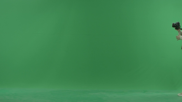 A Young Woman Is Going From the Right Side and Taking Photos Around Her on the Green Screen
