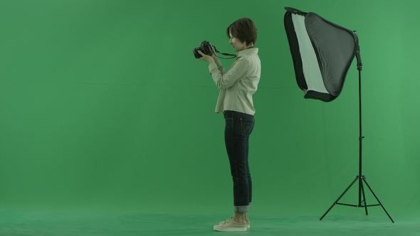A Young Woman Is Trying To Use Camera for the Left Hand Side on the Green Screen