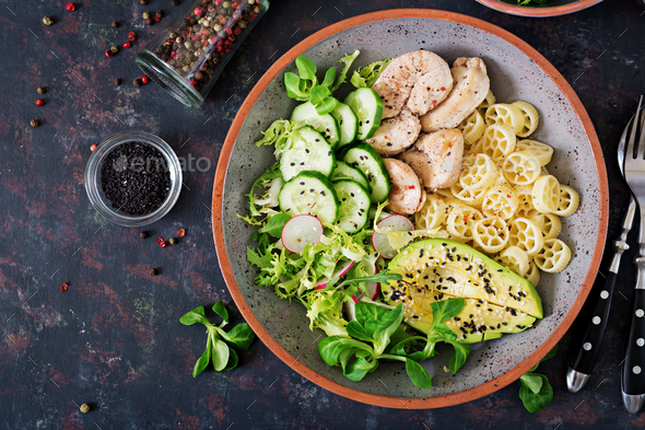 Healthy salad with chicken, avocado, cucumber, lettuce, radish and pasta - Stock Photo - Images