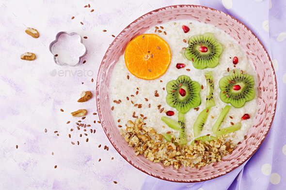 Tasty and healthy oatmeal porridge with kiwi, pomegranate and nuts. - Stock Photo - Images