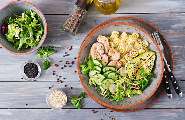 Healthy salad with chicken, avocado, cucumber, lettuce, radish and pasta - Stock Photo - Images