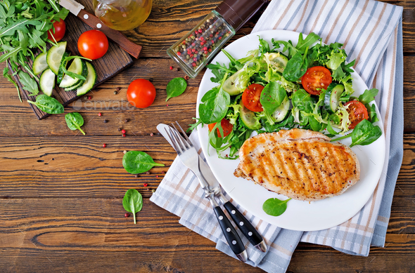 Grilled Chicken Breast And Fresh Vegetable Salad Tomatoes Cucumbers And Lettuce Leaves Stock Photo By Timolina