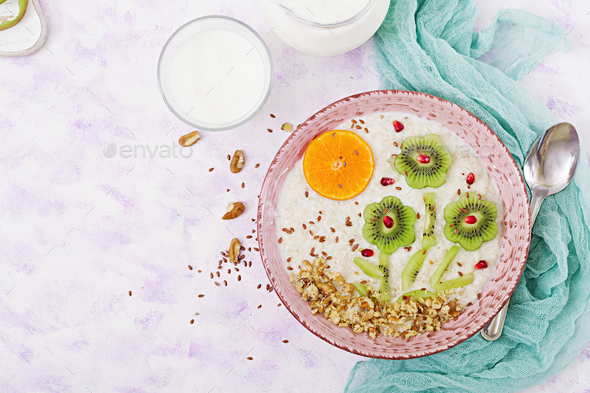 Tasty and healthy oatmeal porridge with kiwi, pomegranate and nuts. - Stock Photo - Images