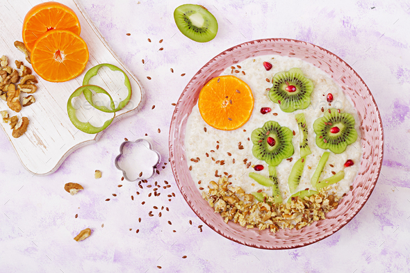 Tasty and healthy oatmeal porridge with kiwi, pomegranate and nuts. - Stock Photo - Images