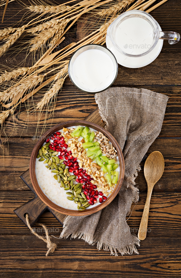 Delicious and healthy oatmeal with kiwi, pomegranate and seeds. - Stock Photo - Images