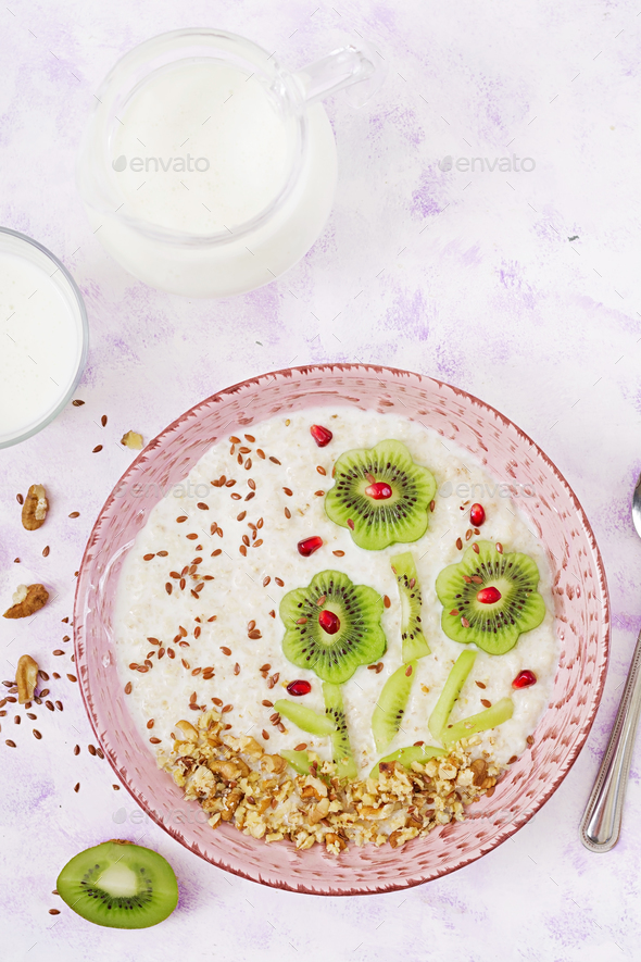 Tasty and healthy oatmeal porridge with kiwi, pomegranate and nuts. - Stock Photo - Images