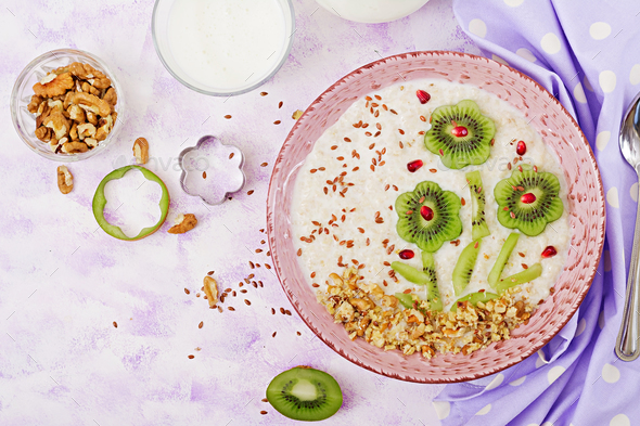 Tasty and healthy oatmeal porridge with kiwi, pomegranate and nuts. - Stock Photo - Images