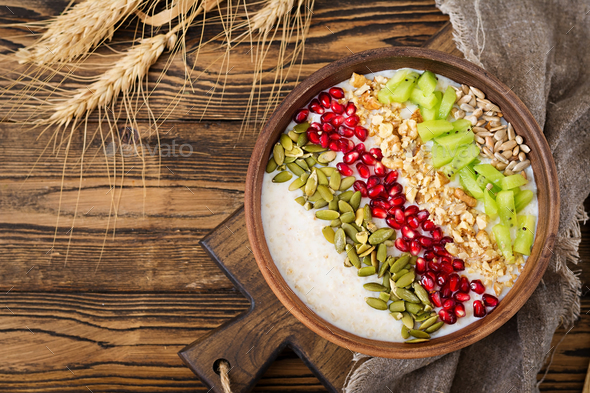 Delicious and healthy oatmeal with kiwi, pomegranate and seeds. - Stock Photo - Images