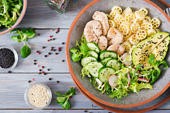 Healthy salad with chicken, avocado, cucumber, lettuce, radish and pasta - Stock Photo - Images