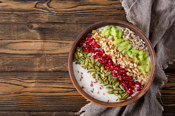 Delicious and healthy oatmeal with kiwi, pomegranate and seeds. - Stock Photo - Images