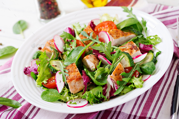 Fresh vegetable salad with grilled chicken breast - tomatoes, cucumbers, radish - Stock Photo - Images