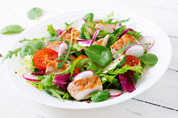Fresh vegetable salad with grilled chicken breast - tomatoes, cucumbers, radish - Stock Photo - Images