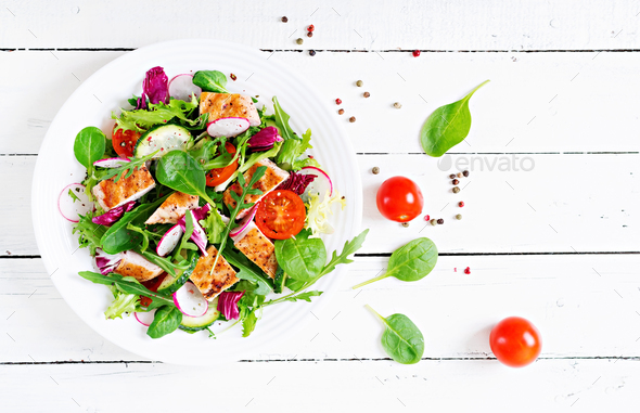 Fresh vegetable salad with grilled chicken breast - tomatoes, cucumbers, radish - Stock Photo - Images