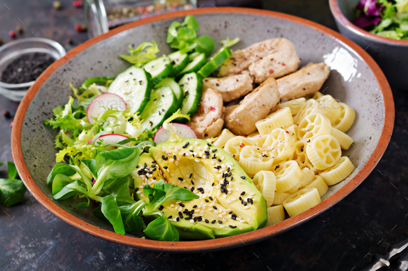 Healthy salad with chicken, avocado, cucumber, lettuce, radish and pasta - Stock Photo - Images