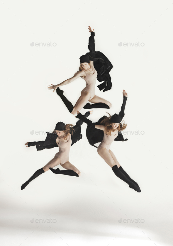 Young beautiful dancer in beige swimsuit dancing on gray background - Stock Photo - Images