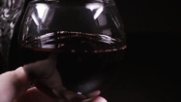 Man's Hand Rotates a Glass of Wine