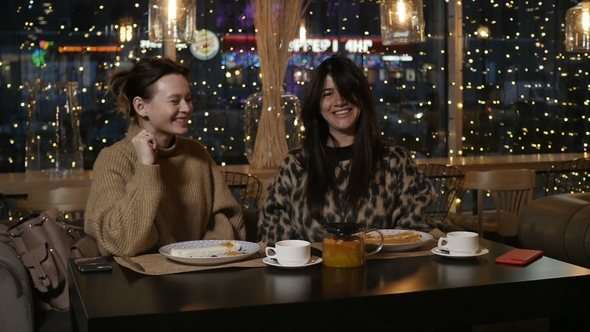 Two Girlfriends Are Smiling While Eating