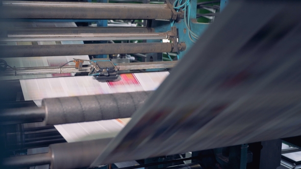 Conveyor with Numerous Freshly Printed Newspapers.  alt