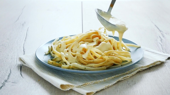 Putting Mushroom Sauce on Tagliatelle Spaghetti. Italian Pasta alt