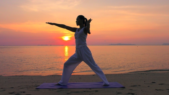 Asian Woman Practicing Yoga at the Sunset Sea