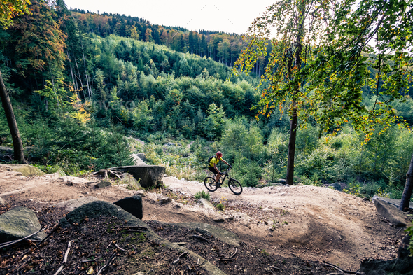 Mountain biker riding cycling in autumn forest - Stock Photo - Images