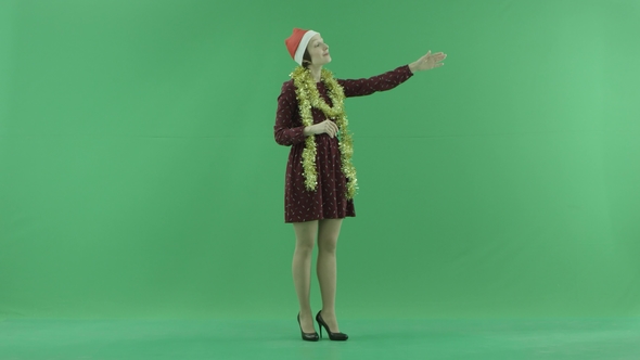 A Young Christmas Woman Calls To Someone From the Right Side on the Green Screen