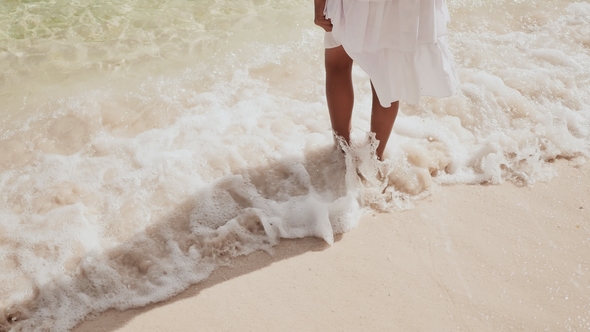 Bare Feet of a Teenage Girl Walking Along the Waves of the Tropical Coast alt
