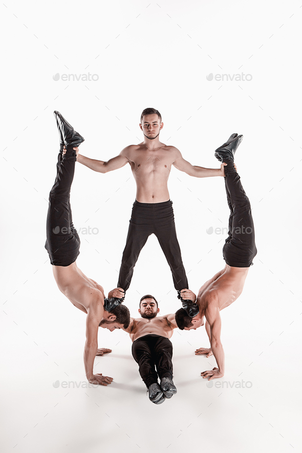 The group of gymnastic acrobatic caucasian men on balance pose - Stock Photo - Images