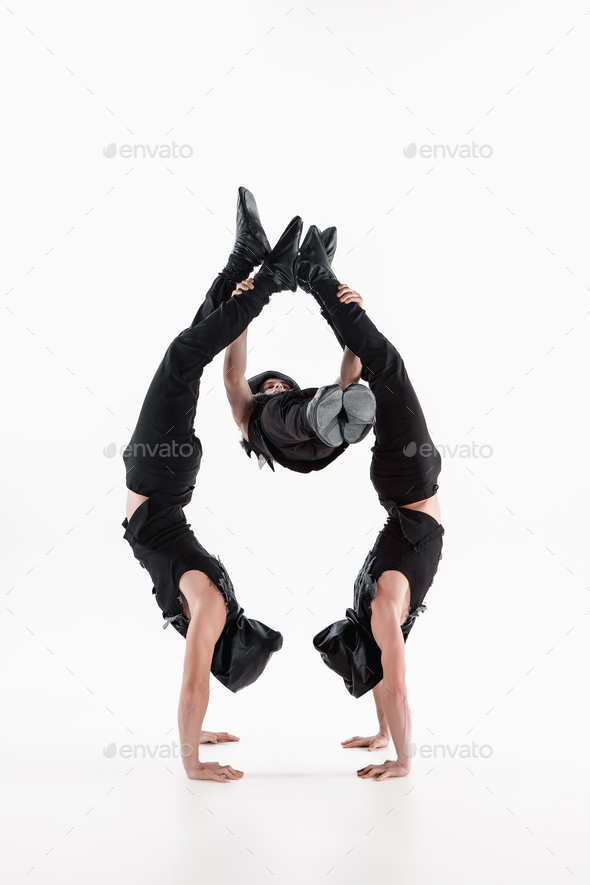 The group of gymnastic acrobatic caucasian men on balance pose - Stock Photo - Images