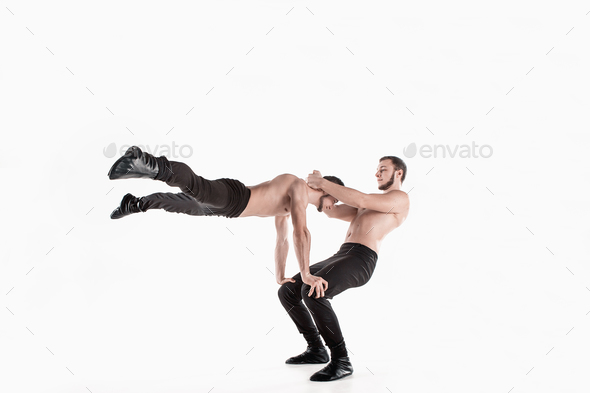 The group of gymnastic acrobatic caucasian men on balance pose - Stock Photo - Images