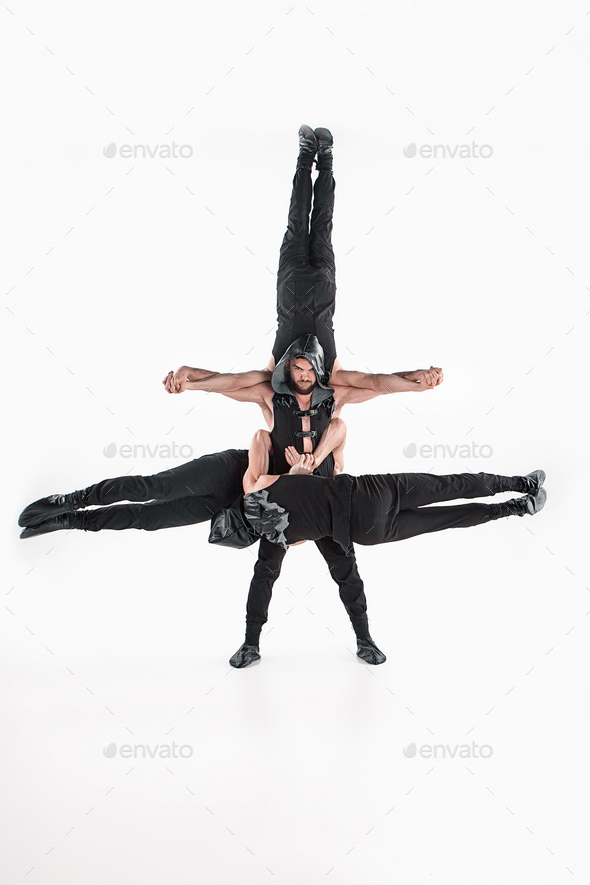 The group of gymnastic acrobatic caucasian men on balance pose - Stock Photo - Images