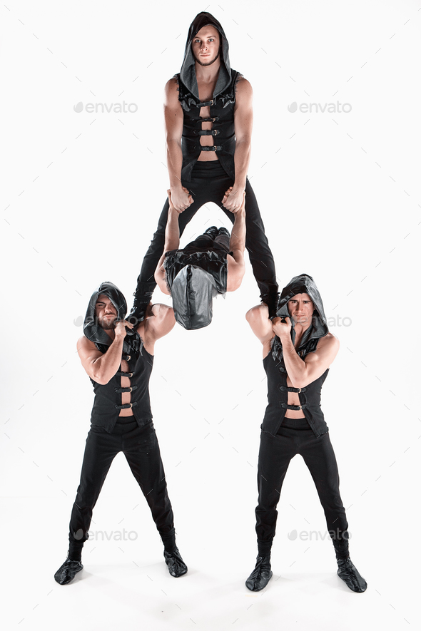 The group of gymnastic acrobatic caucasian men on balance pose - Stock Photo - Images