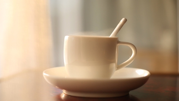 Cup of Hot Tea at Window Side Abstract Blur Background