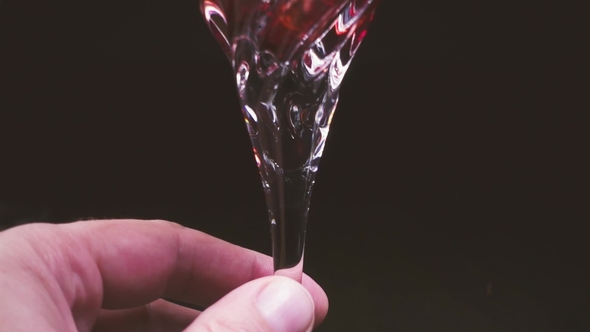 In a Glass on a Black Background, Wine Is Poured From the Decanter