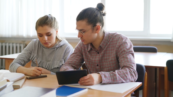 Young College Students Working Together Using Tablet and Discussng Project Preparing for Exams alt