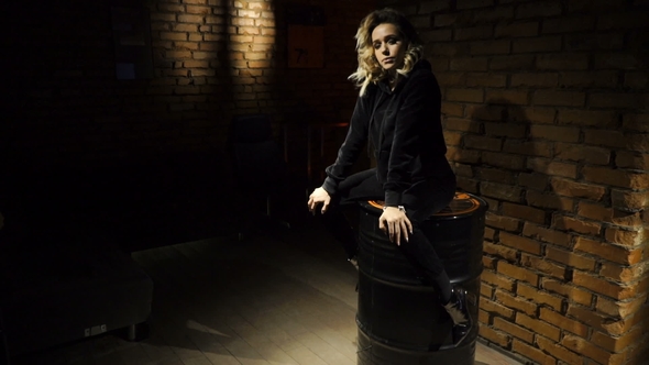 Girl Is Sitting on the Barrel Indoors