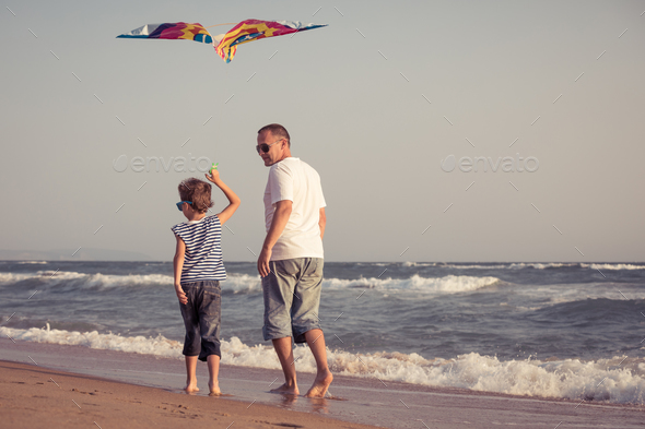 Father and son playing on the beach at the day time. - Stock Photo - Images