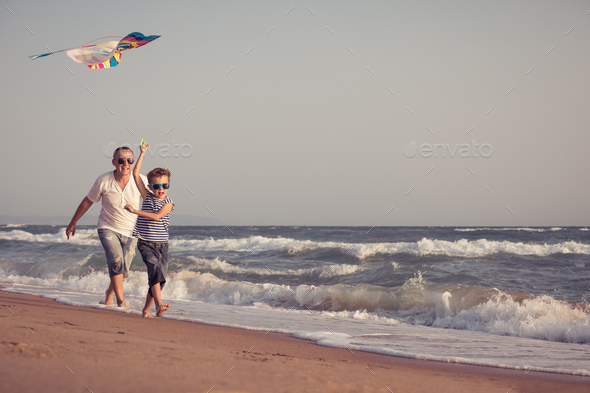 Father and son playing on the beach at the day time. - Stock Photo - Images