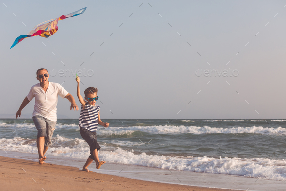 Father and son playing on the beach at the day time. - Stock Photo - Images